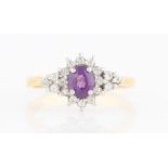 A hallmarked 18ct yellow gold amethyst and diamond cluster ring, set with a central oval cut