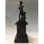 A bronze of Napoleon standing cross armed with an eagle on bronze base with initial stamped to fron
