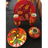A small selection of red and orange Poole pottery to include vases and plates. Five pieces in