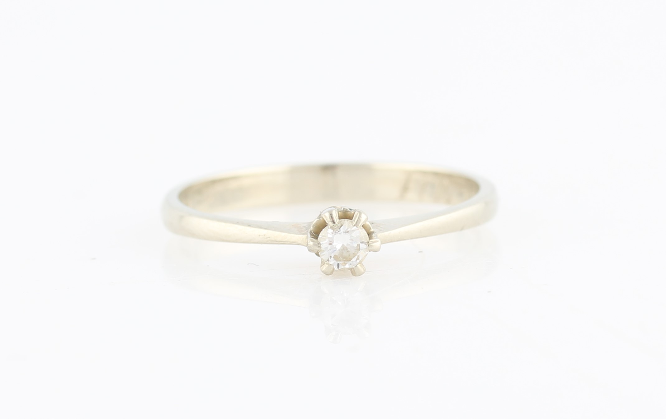 A diamond solitaire ring, set with a round brilliant cut diamond, measuring approx. 0.09ct,