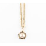 A hallmarked 9ct yellow gold mabe pearl and diamond set pendant, on a hallmarked 9ct yellow gold