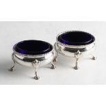 A pair of George III silver salts, engraved with monogram to body and raised on four hoof feet,