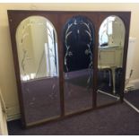 A mahogany framed triple bevelled edged mirror, each frame with arched top, with bevelled floral