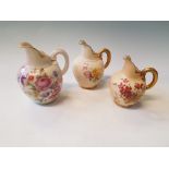 A group of three Royal Worcester graduated water jugs with floral design, with heights of 13cm, 14cm
