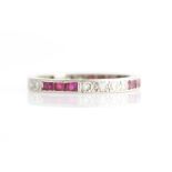 A ruby and diamond full eternity ring, set alternately with three square cut rubies and two sets of