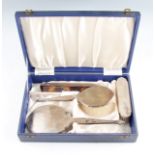 A boxed silver mounted dressing table set, comprising a hair brush, a hand brush, a mirror, and a