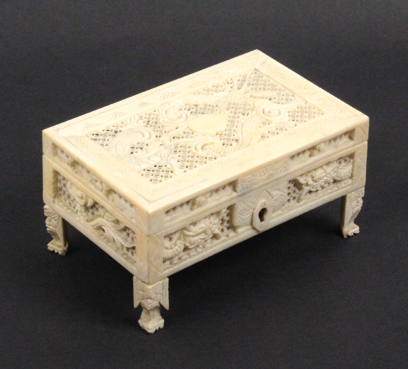 A small 19th Century Chinese carved and pierced ivory box containing miniature items, the