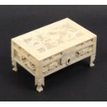 A small 19th Century Chinese carved and pierced ivory box containing miniature items, the