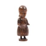 A 19th Century continental carved wood standing figural needle case in the form of a woman wearing a