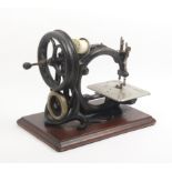 A late 19th Century Wilcox and Gibbs chain stitch sewing machine on wooden plinth base, platform