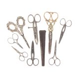 Eight pairs of scissors comprising a pair with curved blades to scroll work silver handles, 12cm,