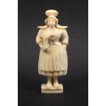 A 19th Century carved ivory Dieppe standing needle case, well carved as a woman in traditional