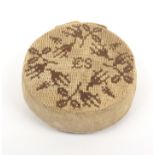 An 18th Century circular sampler style knitted pin cushion, one side initialled 'ES' amid flowers