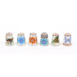 Six silver and enamel thimbles by James Swann and Son comprising four floral and two of insects,