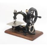 A late 19th Century Wilcox and Gibbs chain stitch sewing machine on wooden plinth base, platform