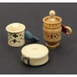 Three tape measures comprising a pierced ivory cylinder example, old tape within, a vegetable