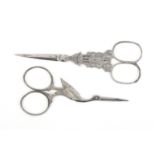 Two pairs of 19th Century attractive steel scissors comprising a pair with oval section tapering