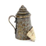 A brass novelty tape measure in the form of a floral decorated beer stein, wound from the lid, the