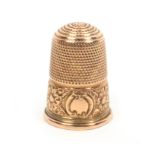 A 19th Century gold thimble in leather case, the frieze decorated with flower heads and leaves