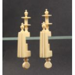 A pair of 19th Century ivory winding clamps, the rectangular reeded frames below delicate turned