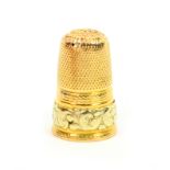 A 19th Century two colour gold thimble, probably French, the frieze with a leaf scroll raised design