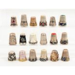 Eighteen continental white metal thimbles including seven with part enamelled friezes, one jewelled,