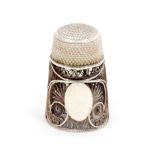 A late 18th Century silver filigree thimble, oval vacant cartouche within quill work below a solid