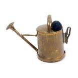 A scarce brass combination novelty tape measure/pin cushion in the form of a watering can, the