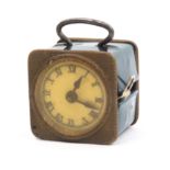 A brass novelty tape measure in the form of a travel clock, the retractable tape in ins and cm and