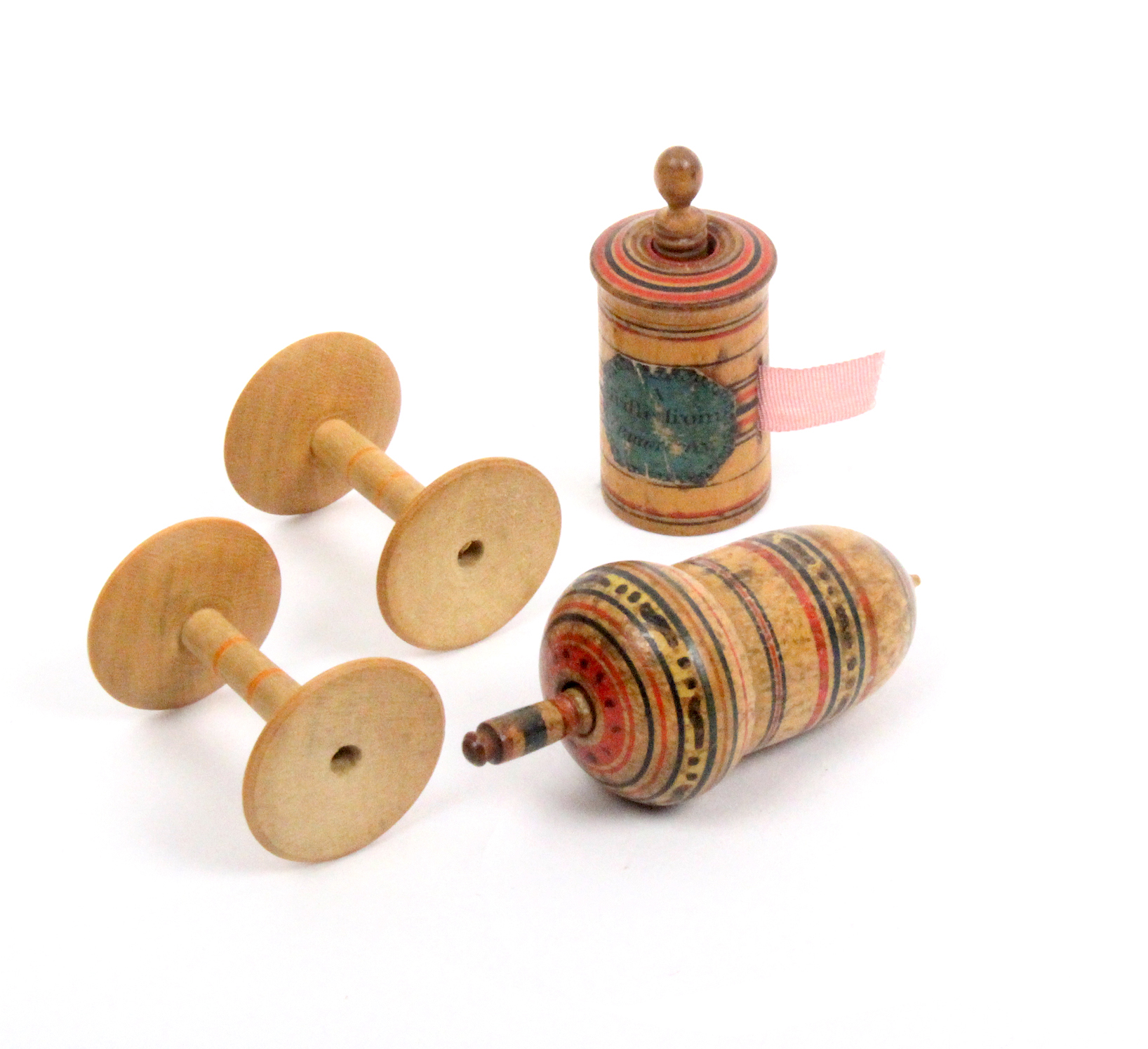 Two early painted Tunbridge ware tape measures and two reels comprising an acorn form example, the