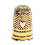 An early 19th Century continental gold thimble, the engine turned frieze below a shield, slight loss