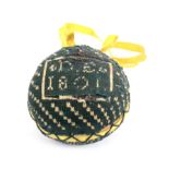 An early 19th Century knitted pin ball, the green knitted ground with geometric motifs, one side