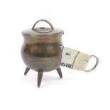 A brass novelty tape measure in the form of a lidded cauldron, wound by the lid, the complete