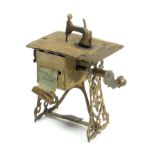 A scarce brass novelty tape measure in the form of a treadle sewing machine, faded but complete tape