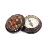 A Tunbridge ware circular rosewood box containing a compass, the lid with a hexagonal panel of