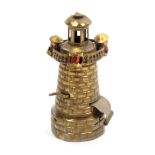 A brass novelty tape measure in the form of a light house, the balustrade gallery misshapen and with