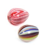 Two attractive coloured glass egg form darners, one in red glass with white stripes, 6.8cm, the