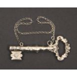 A continental white metal needle case in the form of a decorative key on suspension chain, 9.5cm