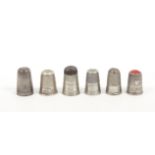 Six various silver thimbles comprising an early 19th Century steel top example, a plain tall