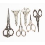 Four pairs of silver handled scissors and two decorative silver sheaths one with hanging chain,