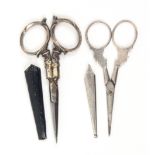 Two pairs of scissors comprising a pair of late 19th century Dutch silver mounted scissors, steel