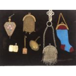 A group of purses and other items mounted on velvet board, comprising a bellow form metal pin