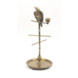 A Victorian brass reel stand as a parrot on a perch, the circular base on three ball feet, the