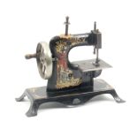 A child's sewing machine, circa 1900, the frame decorated with colour transfers of a young girl