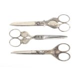 Three pairs of larger format steel scissors comprising two pairs with portrait medallions, the first