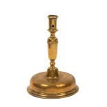 A 17th Century brass candlestick probably Spanish, on a domed base, 22cm high, 16cm dia. at base. *