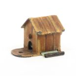 An Austrian cold painted novelty metal tape measure in the form of a dog kennel, the complete