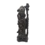 A large 19th Century Chinese carved blackwood figure of Shou Lao, bearded holding a peach and staff,