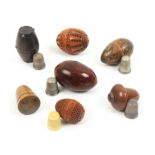 Seven thimble cases, comprising two coquilla nut pierced egg form examples, 5cm and 4cm, a wooden