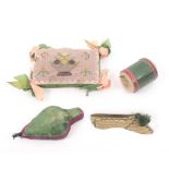 Four pin cushions comprising a green leather drum form example, 3cm, another as a set of bellows